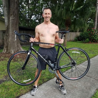 45 year old person holding a bike